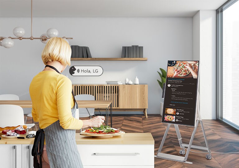 Una mujer está usando comandos de voz para controlar One:Quick Flex mientras cocina.