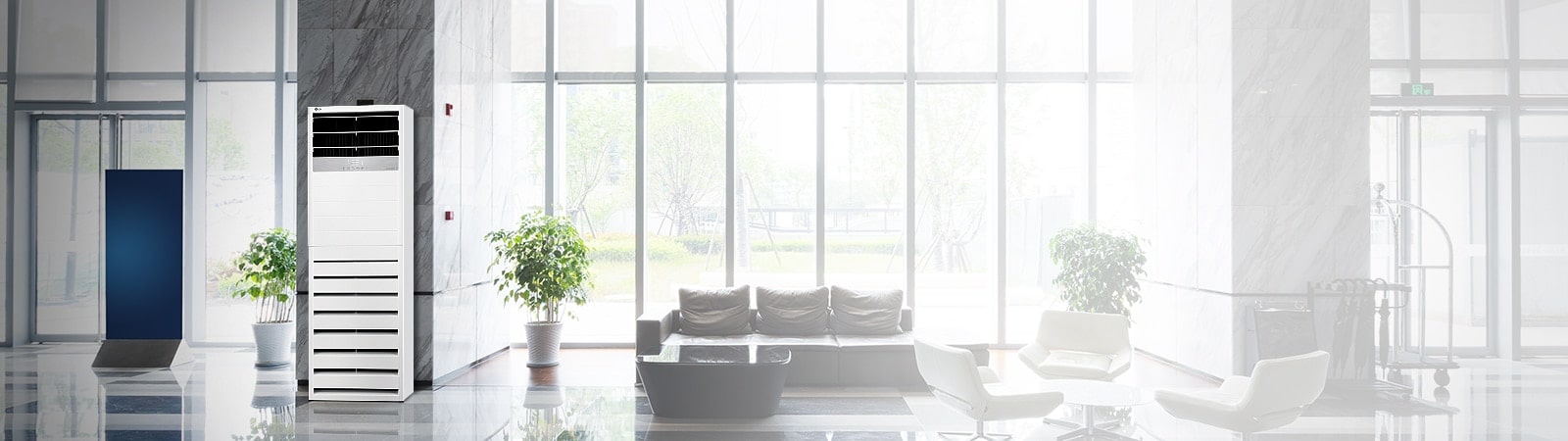 LG Floor Standing Unit is positioned in front of a marble pillar in the lobby area of a modern hotel, flanked symmetrically by two plants.
