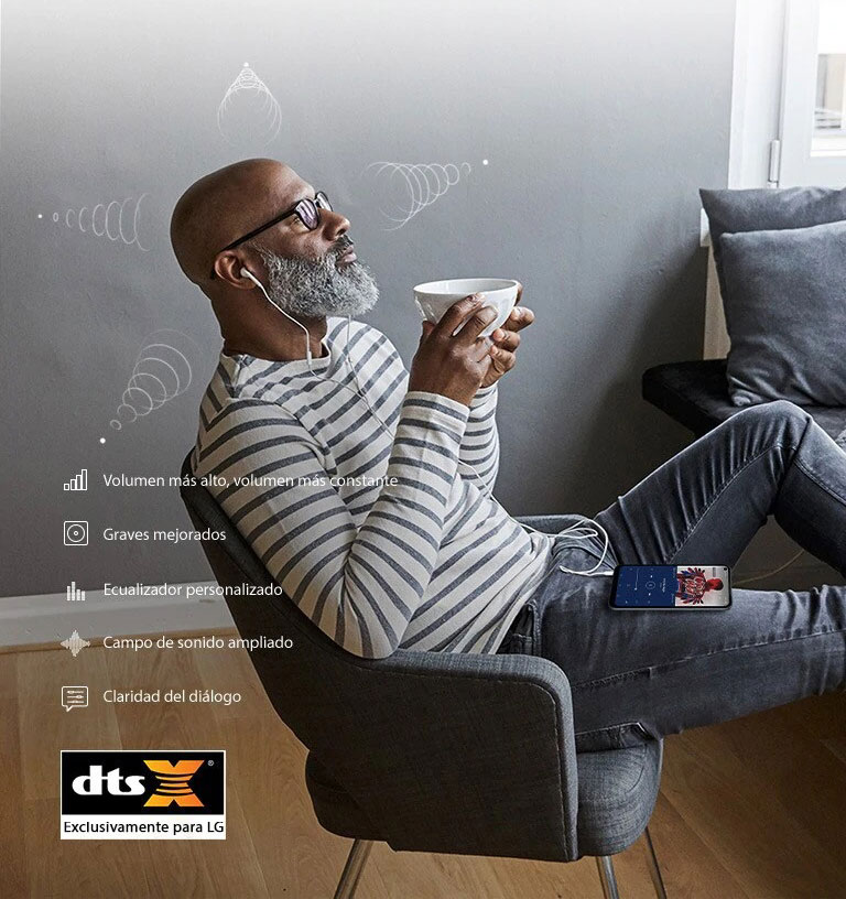 Hombre sentado en una silla tomando café y escuchando música a través de sus auriculares