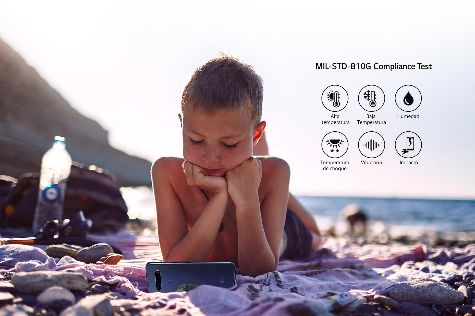 Niño acostado en la playa y viendo una película en su Smartphone