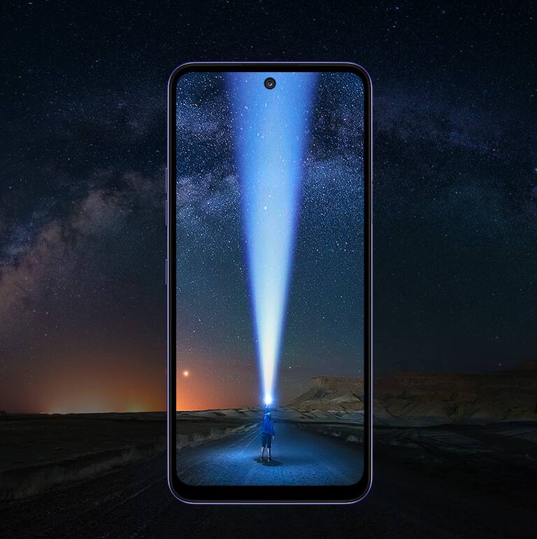 Niño que ilumina con una linterna el cielo en la carretera.