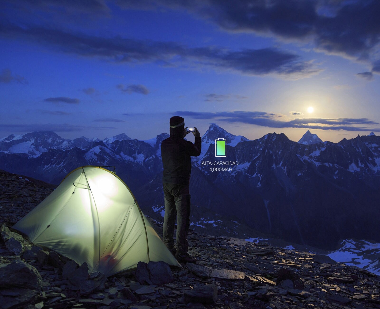 Hombre que toma fotografías en la cima de una montaña.
