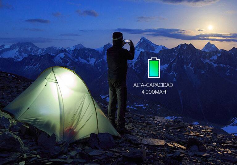 Hombre que toma fotografías en la cima de una montaña.