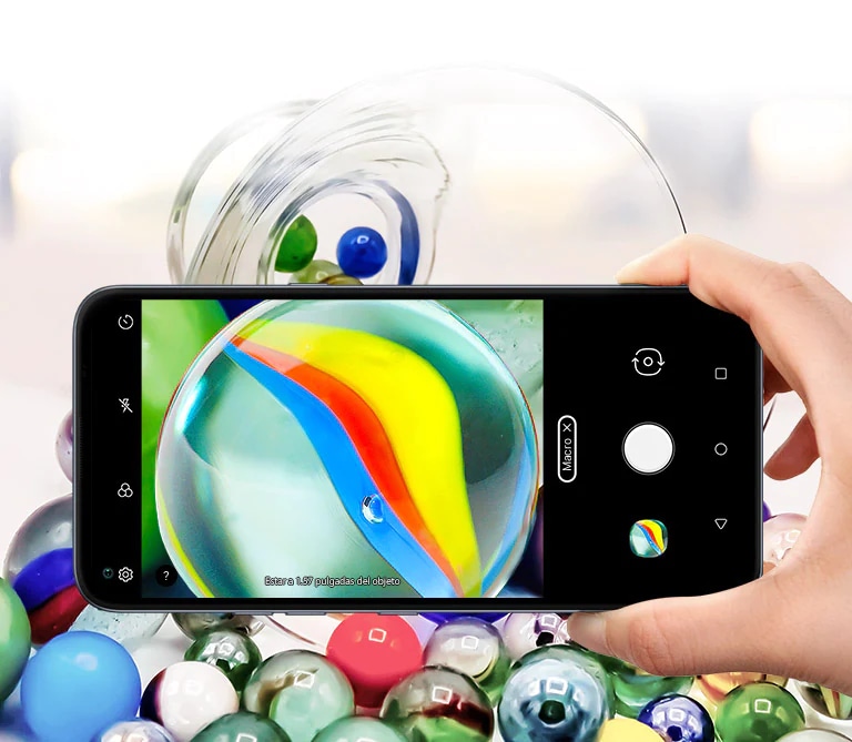 Closeup of someone holding a smartphone taking a picture of some marbles