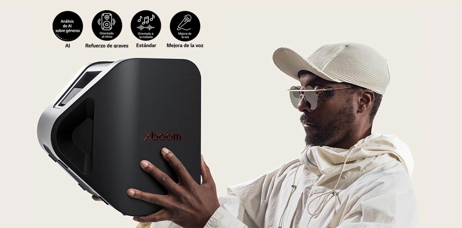 will.i.am con traje blanco y gorra blanca sostiene el xboom Stage 301 con ambos brazos en la cara.