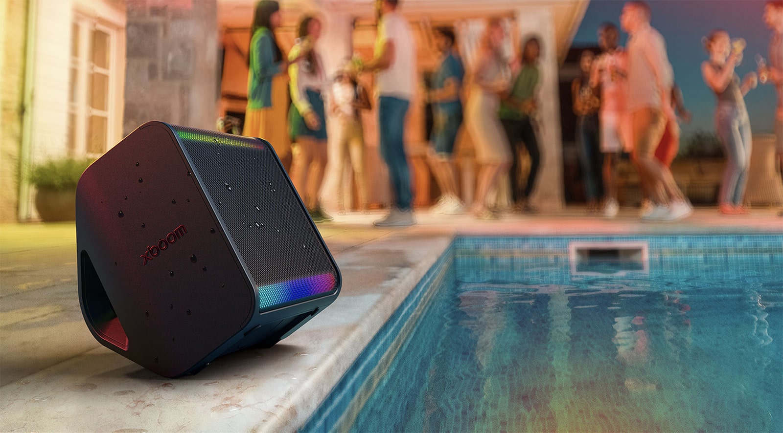 Se muestra una piscina al aire libre y una multitud de personas detrás. El xboom Stage 301 está ubicado frente a la piscina con algunas salpicaduras de agua sobre él.