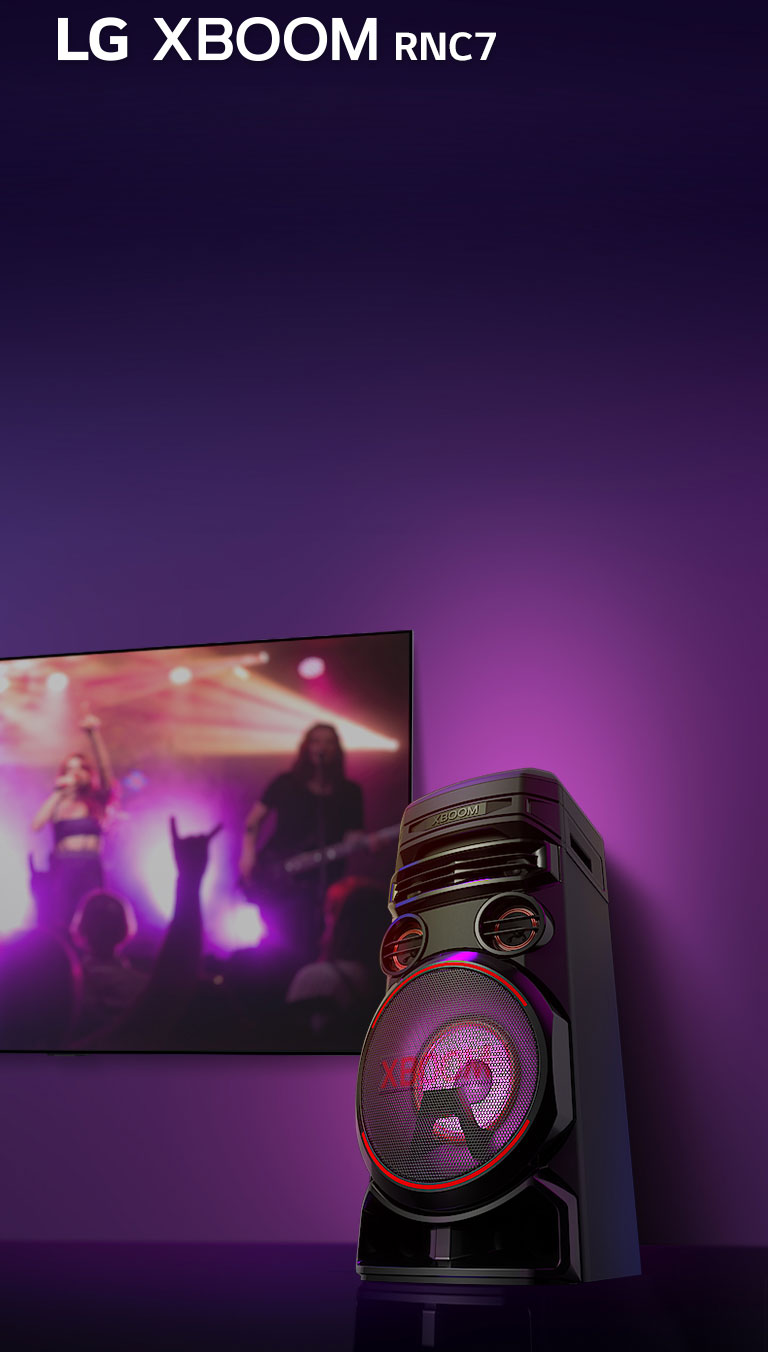 Una vista de ángulo bajo del lado derecho del LG XBOOM RNC7 contra un fondo morado. Las luces XBOOM también son moradas. Y una pantalla de televisión muestra una escena de concierto.