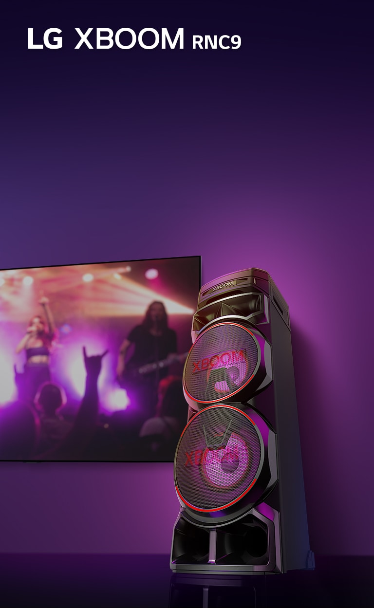 Una vista de ángulo bajo del lado derecho del LG XBOOM RNC5 contra un fondo morado.<br> Las luces XBOOM también son moradas. Y una pantalla de televisión muestra una escena de concierto.