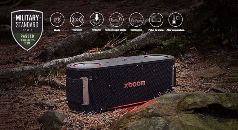 El xboom Bounce está sobre hojas mojadas, entre una raíz y una piedra. En la esquina superior izquierda, el logo militar.