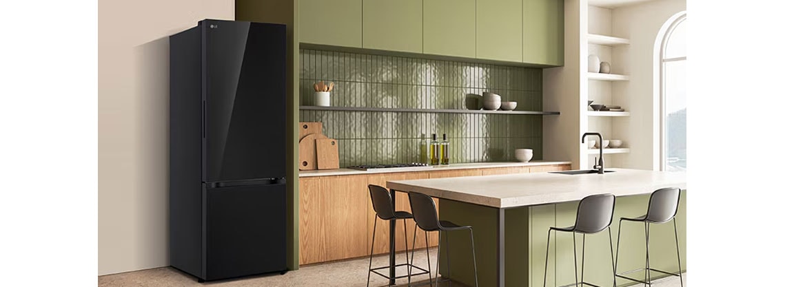 La vista lateral del refrigerador LG bottom freezer con instaview con armarios verdes y una elegante isla.