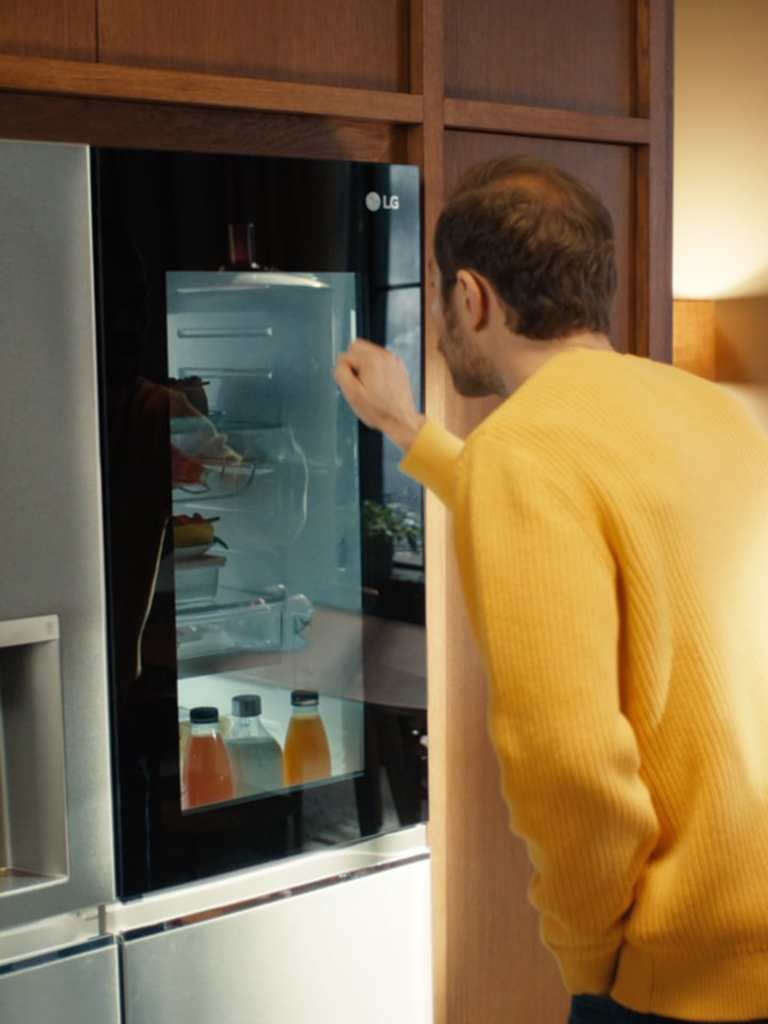Hombre usando el refrigerador LG InstaView