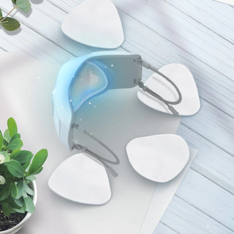 Se muestra la parte interior de la mascarilla vista desde arriba, mostranto la cubierta interior y los filtros interiores alrededor, todo sobre una mesa. Se ha resaltado de color azul la zona donde debe ir el filtro interior.  