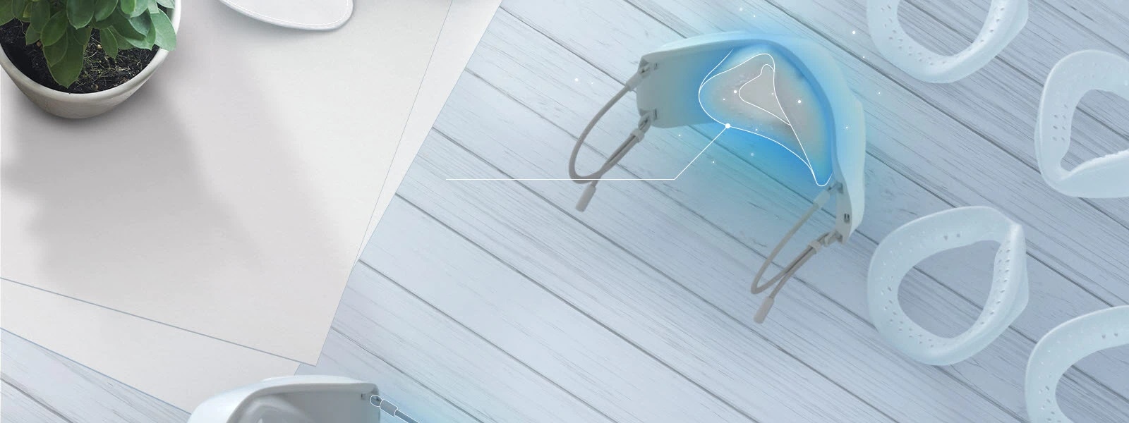 Se muestra la parte interior de la mascarilla vista desde arriba, mostranto la cubierta interior y las piezas del protector de silicona alrededor, todo sobre una mesa. Se ha resaltado de color azul la zona donde debe ir el protector facial.  