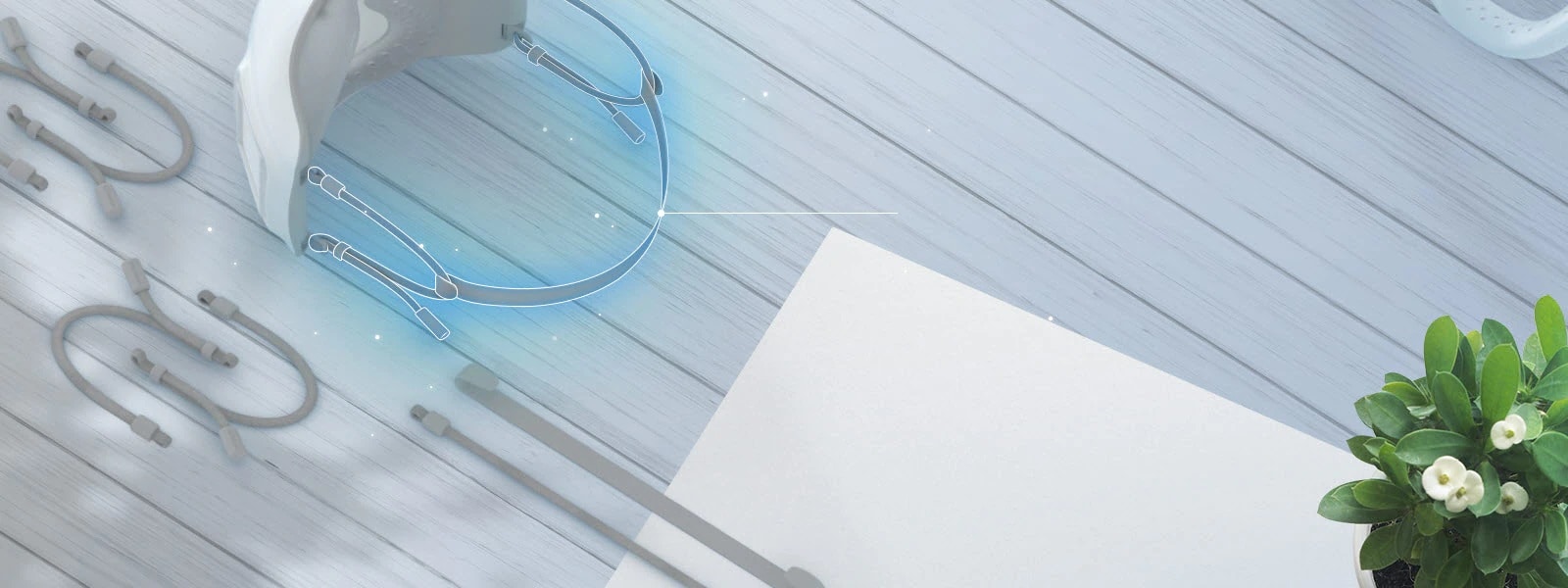 Se muestra la parte superior e interior de la mascarilla vista desde arriba, resaltando en color azul las bandas elasticas sujetas. Las bandas extra-elásticas aparecen alrededor de la mascarilla sobre la mesa.