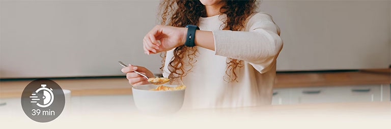 Una mujer en la mesa mira su reloj de pulsera durante una comida ligera
