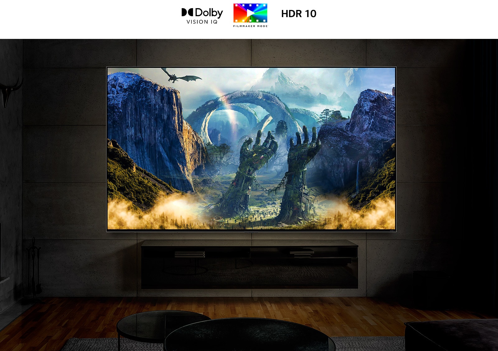 Un televisor ultra grande montado en una pared en una habitación oscura. La pantalla muestra una escena de fantasía con un dragón respirando fuego hacia el suelo.