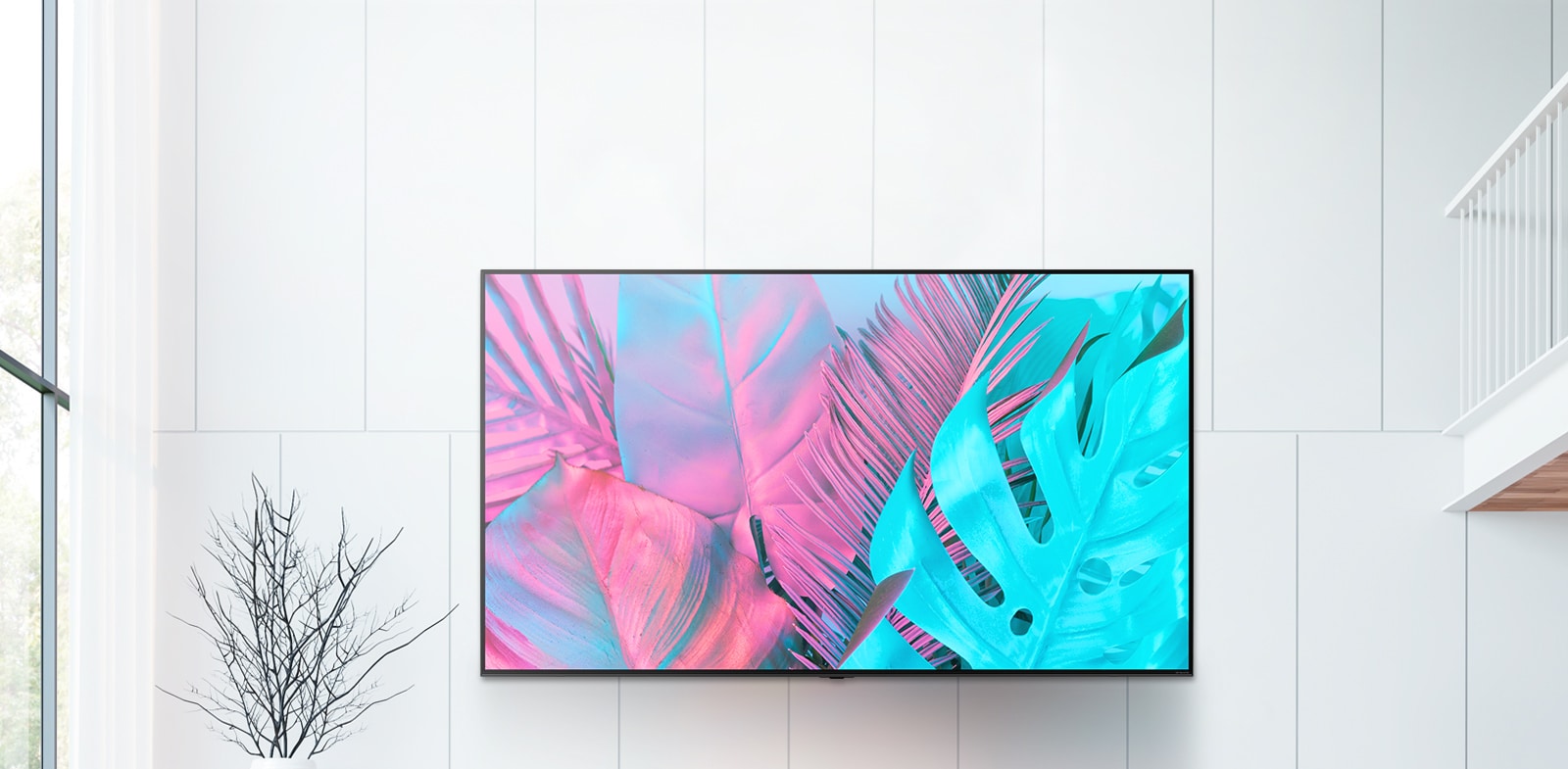 Un TV de pantalla plana grande montado en una pared de color blanco. La pantalla muestra hojas grandes en colores brillantes.