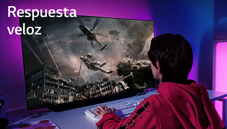 Una niña está jugando a un videojuego en una gran pantalla de un televisor que muestra a un soldado bajando de un helicóptero.