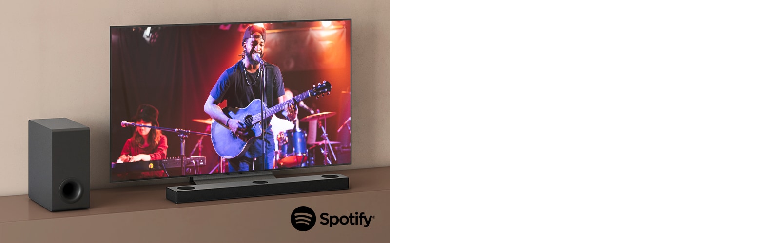 El televisor LG muestra un concierto y la barra de sonido LG se coloca debajo del televisor LG. A la izquierda, el subwoofer está en el estante marrón.