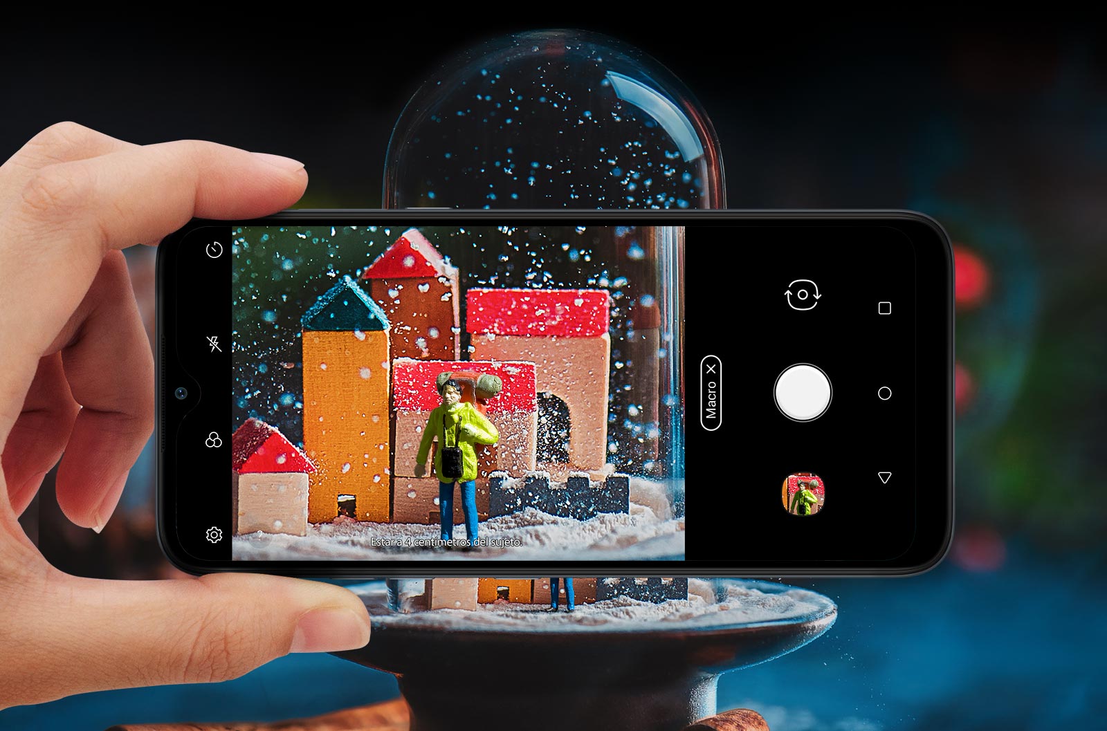 Primer plano de alguien sosteniendo un Smartphone tomando una foto de una bola de nieve