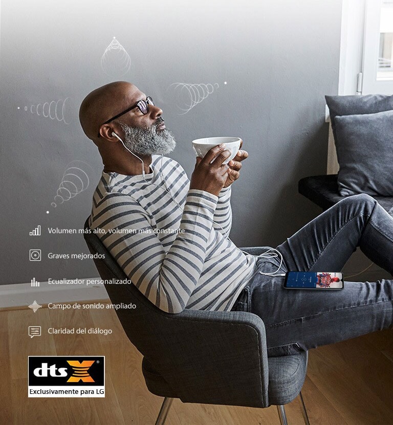 Hombre sentado en una silla tomando café y escuchando música a través de sus auriculares