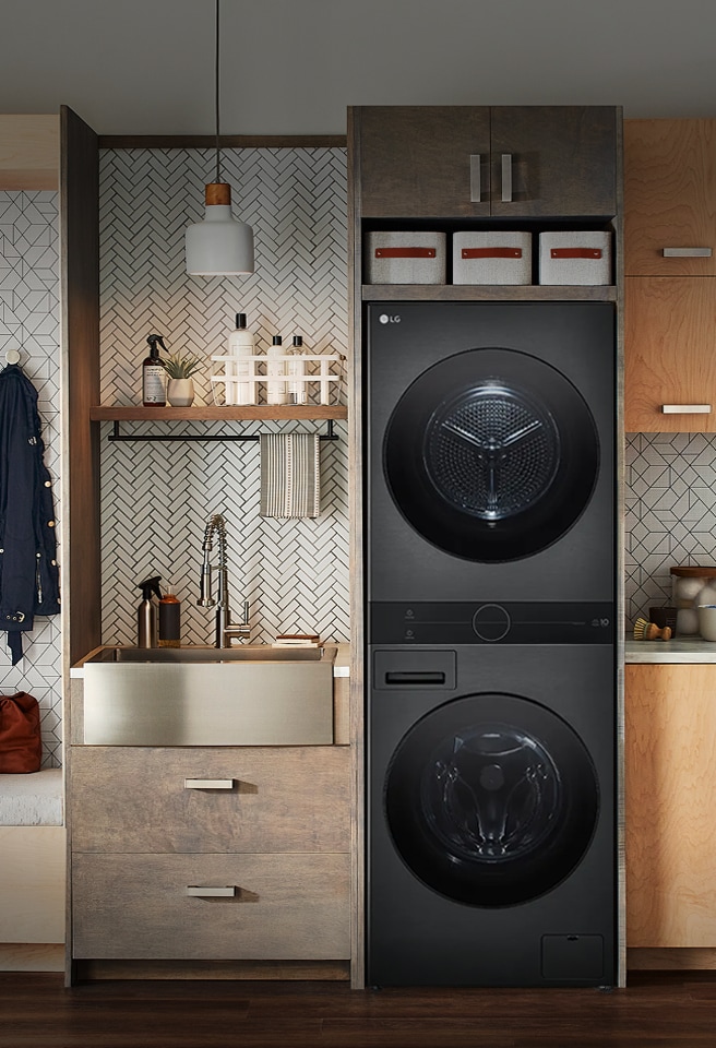 Lavarropas y secarropas apilados empotrados de LG en un lavadero moderno con muebles de madera y banco para sentarse.