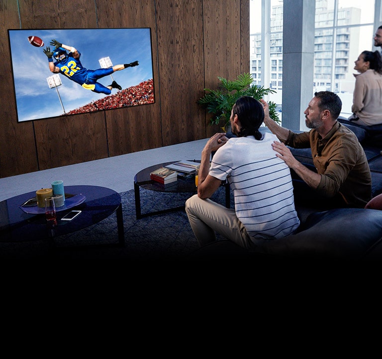 Personen, die sich ein Spiel von "Tottenham" in ihrem Wohnzimmer auf dem Fernseher ansehen