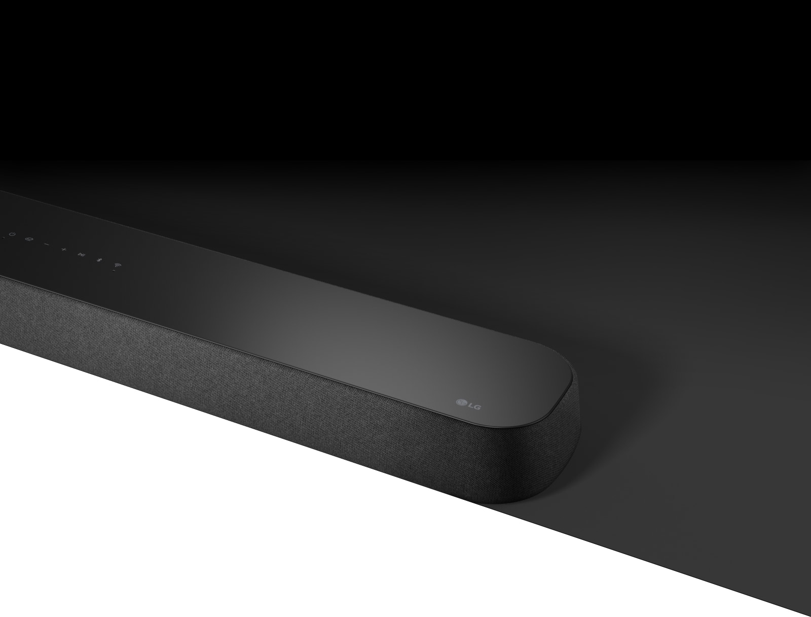 Die LG Soundbar DSE6S mit diagonaler Ansicht ist auf einer schwarzen Fläche platziert und darunter befindet sich eine weiße Fläche für Designzwecke.