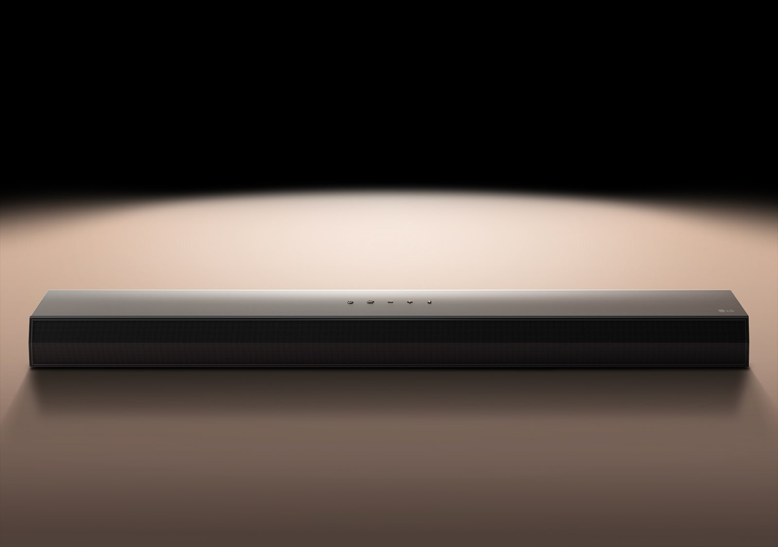 LG Soundbar vor einem schwarzen Hintergrund, der von einem Scheinwerfer angestrahlt wird.
