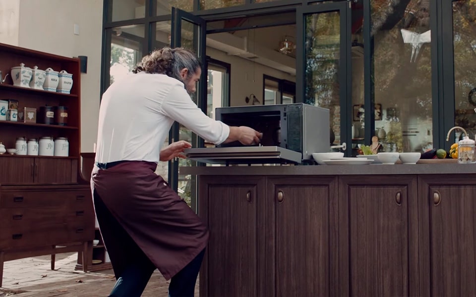 A man placing food inside the LG NeoChef