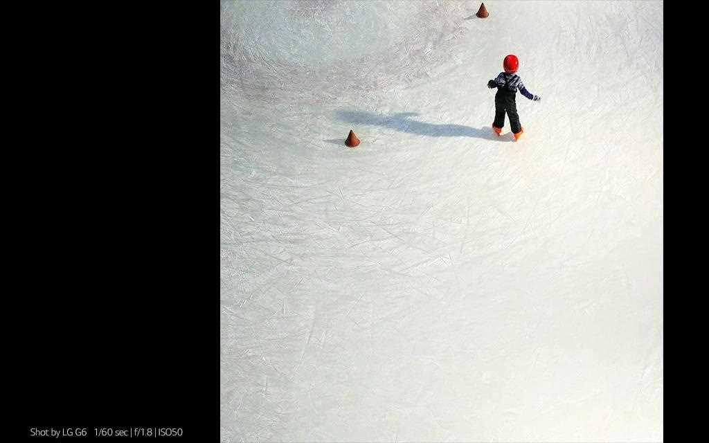 A photography of little child riding ice skate shot by lg g6