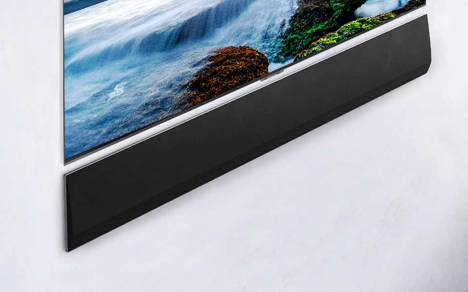 The LG Soundbar GX placed flush on the wall underneath an LG TV. 