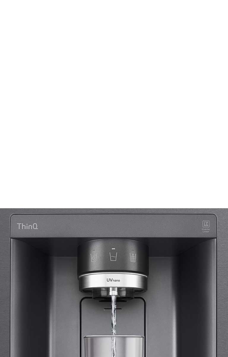 A video/image zoomed in on the water dispenser. Water droplets as they fall through the UVnano part of the nozzle which reduces the bacteria. We see the exterior of the refrigerator again as water is being dispensed into a glass.
