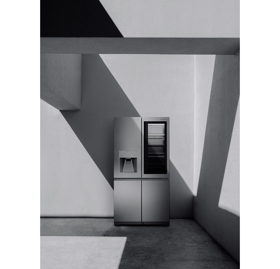 a black and white image of lg signature refrigerator which is laid against the wall with some structures and shadow coming from those fabrications