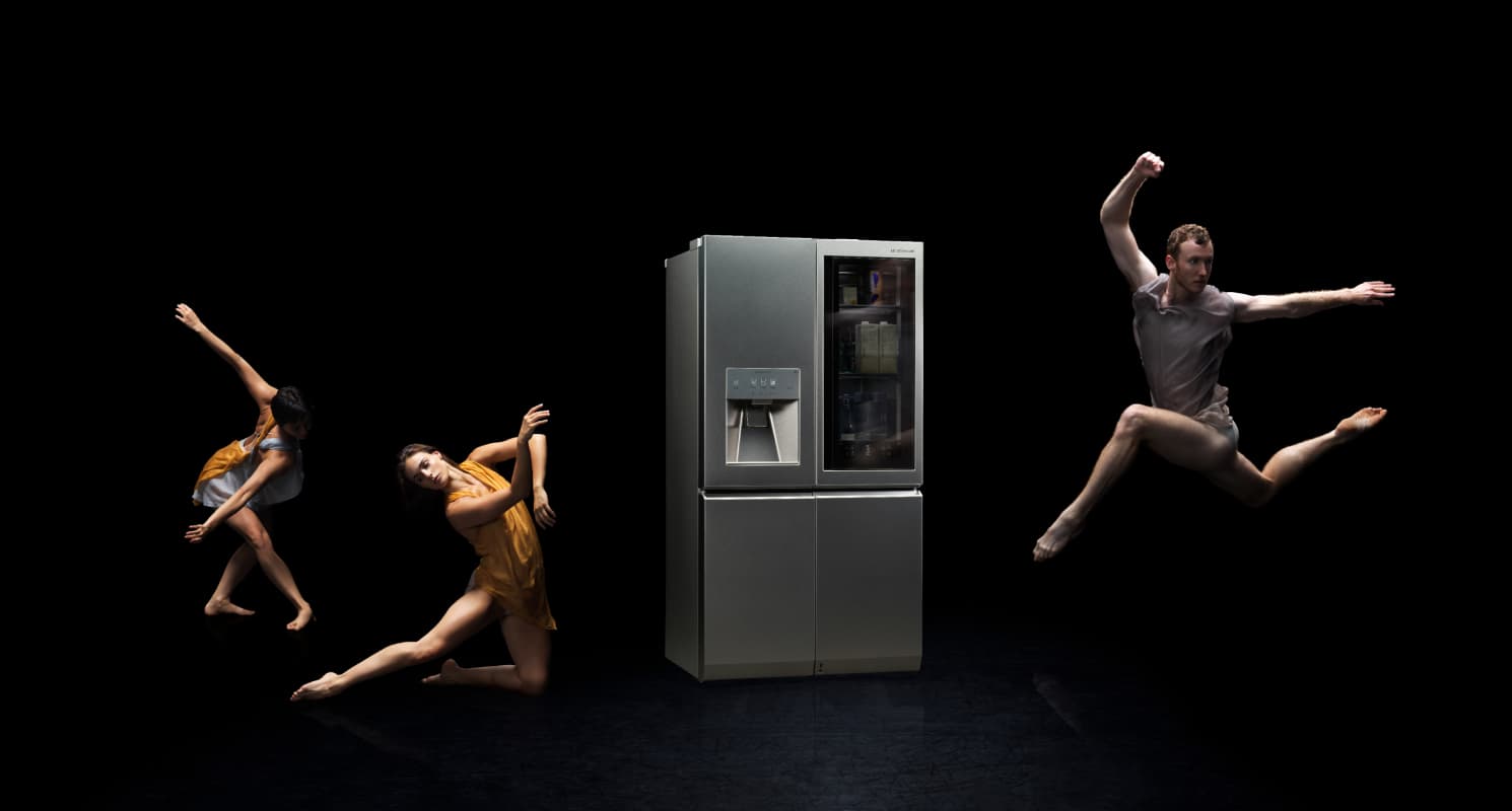 Ballet dancers performing around an LG SIGNATURE Refrigerator against a black backdrop.