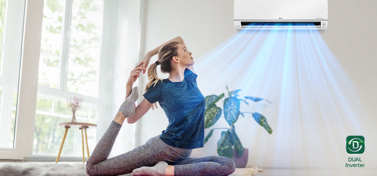 A woman is stretching on the floor. In the background is the air conditioner and blue air flows out over the woman and the room. The Dual Inverter logo is in the bottom right corner.