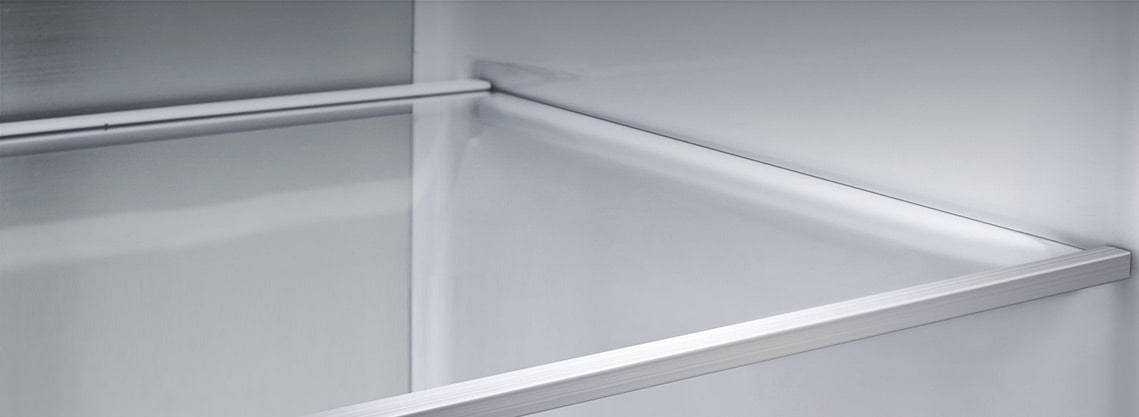 A diagonal view of the shelf with metallic paneling on the interior of the refrigerator.