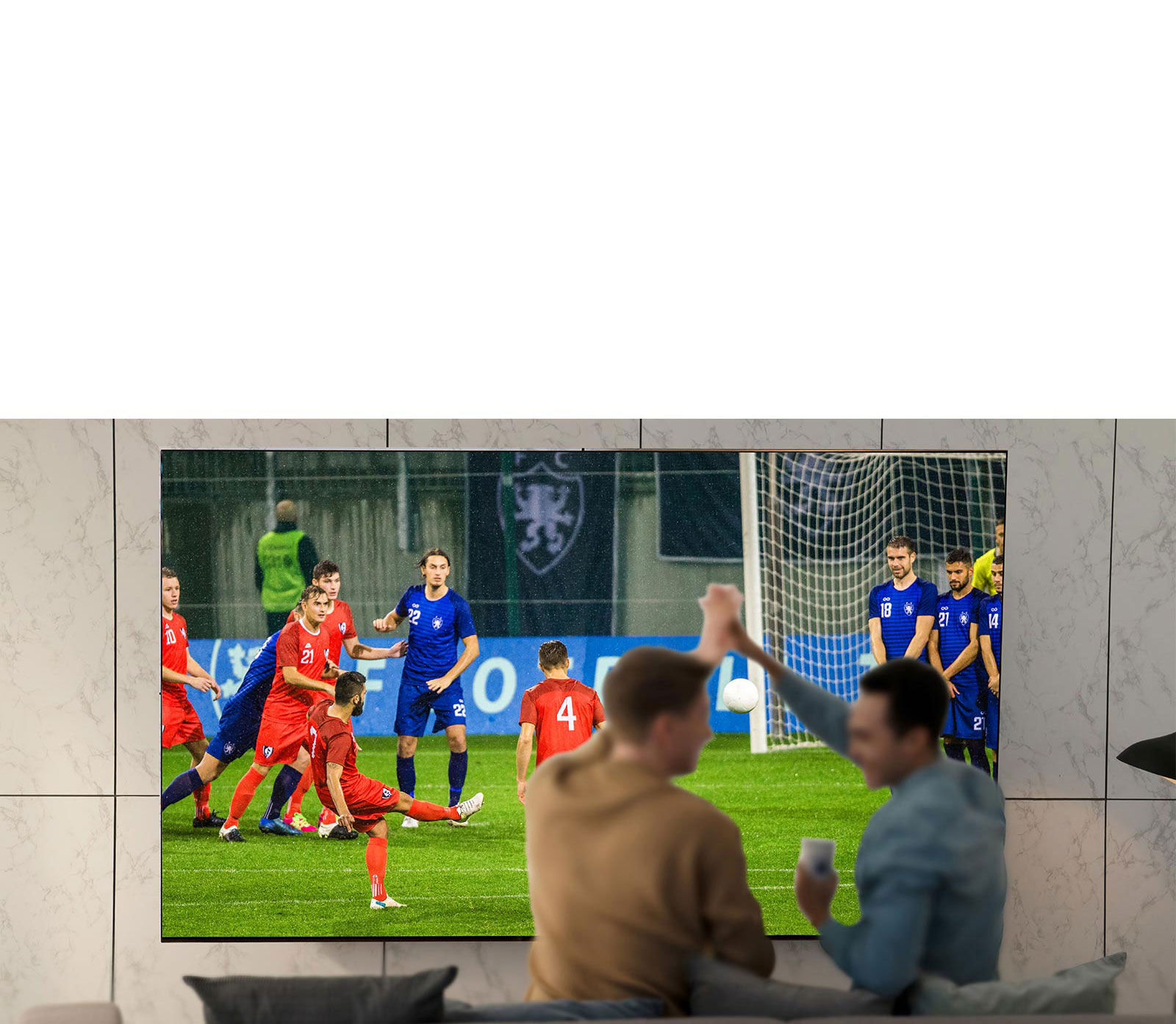 People watching sports game on TV in the living room with ultra large scree TV