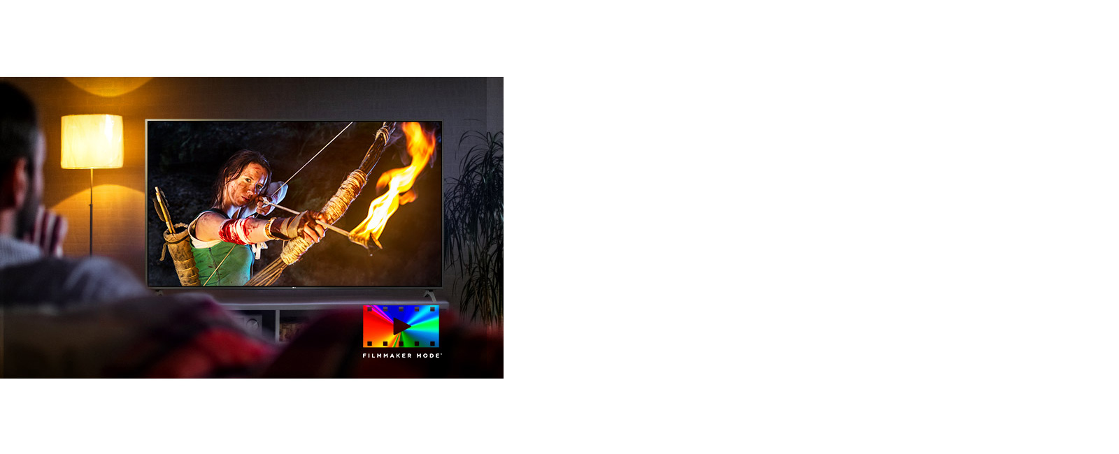 A man is sitting on a couch watching an action movie. The girl on the TV has a fully drawn bow and arrow.