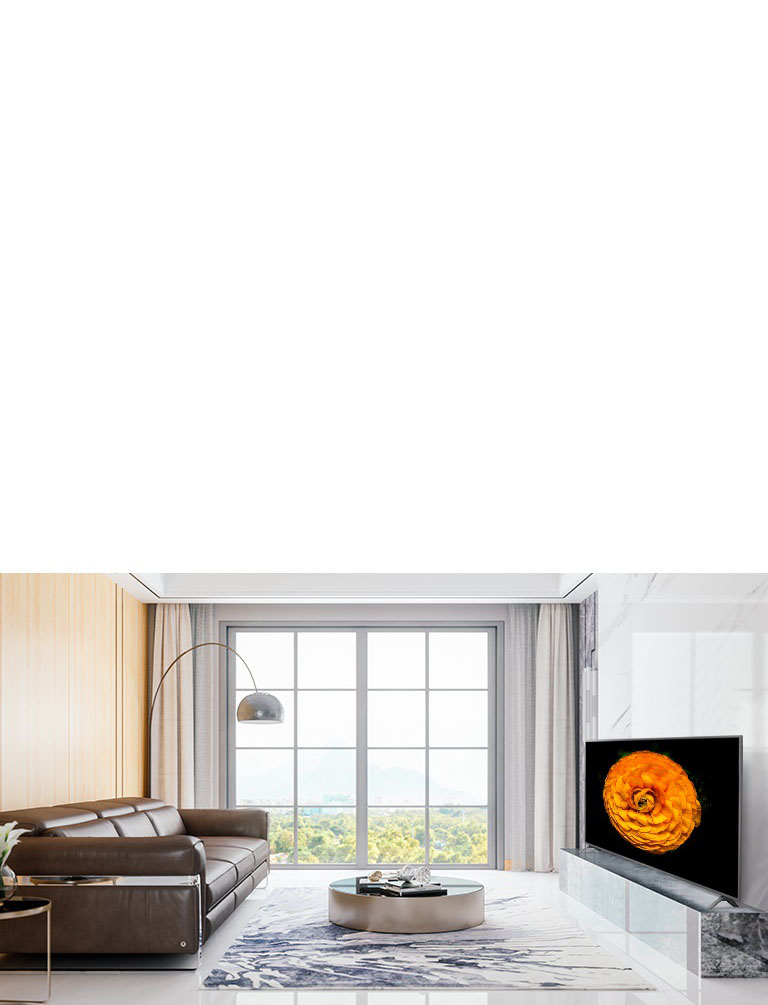 LG UHD TV, located on the wall in a living room with the minimal interior. Image of a flower is shown on the TV screen.