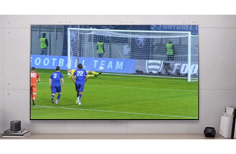 A TV screen showing a football player scoring a penalty (play the video).