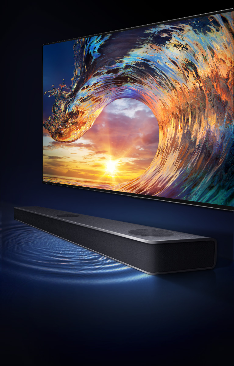 TV shows the sunset sky and rainbow-colored waves. There is a sound bar under the TV and the sound wavelength is on the floor.