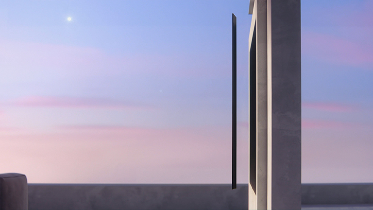 A side view of a slim design TV that is about to be hung on the wall.