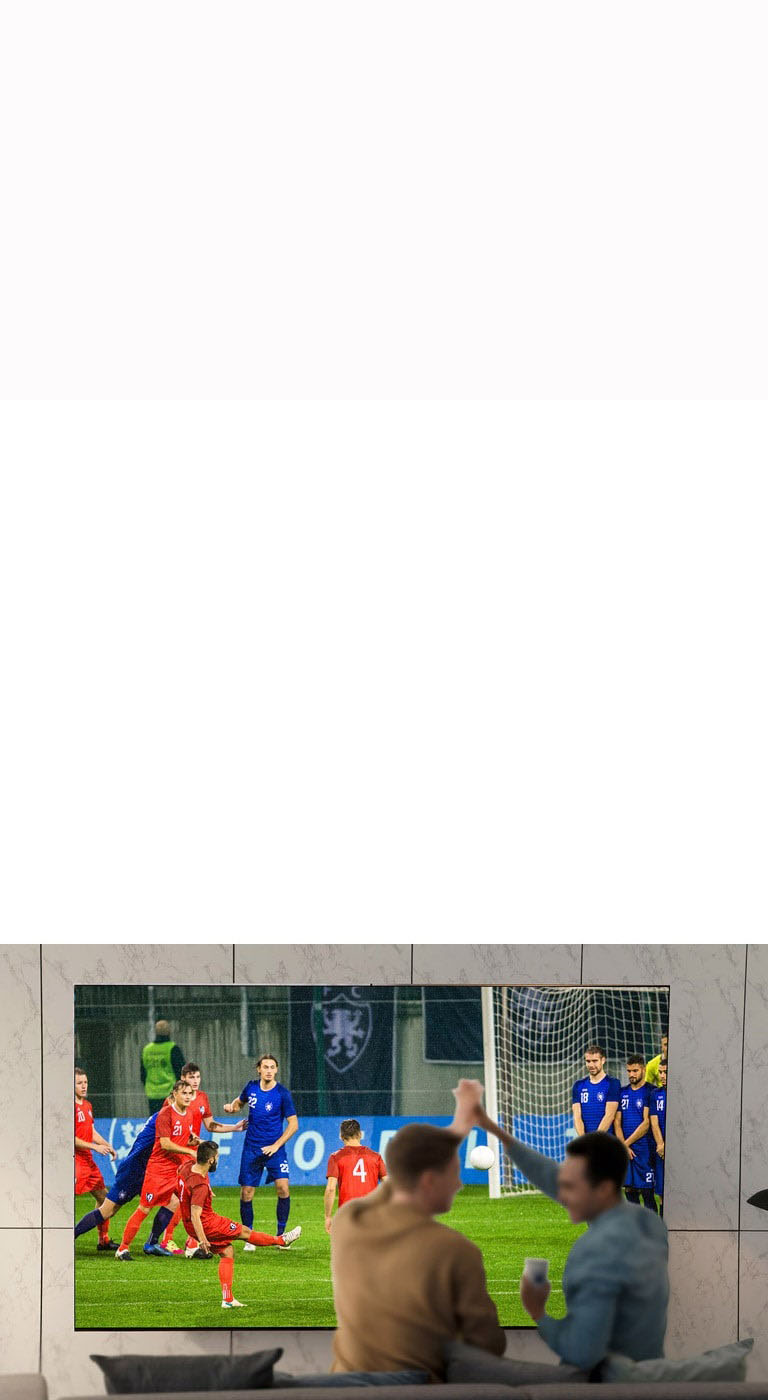 People watching sports game on TV in the living room with ultra large scree TV