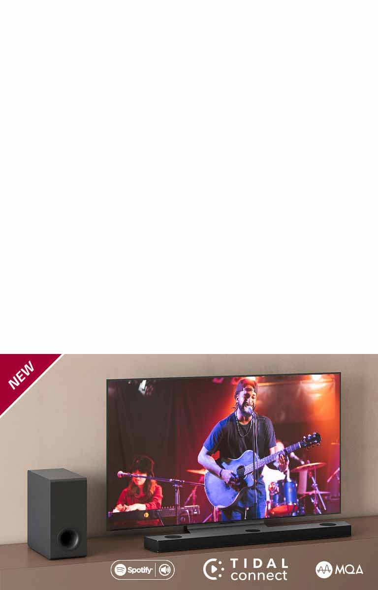 Le téléviseur LG est placé sur le meuble marron, devant lui se trouve la Barre de son LG S90QY. Le caisson de basses est placé sur la gauche du téléviseur. Le téléviseur affiche une scène de concert. La marque NEW est affichée dans le coin supérieur gauche.