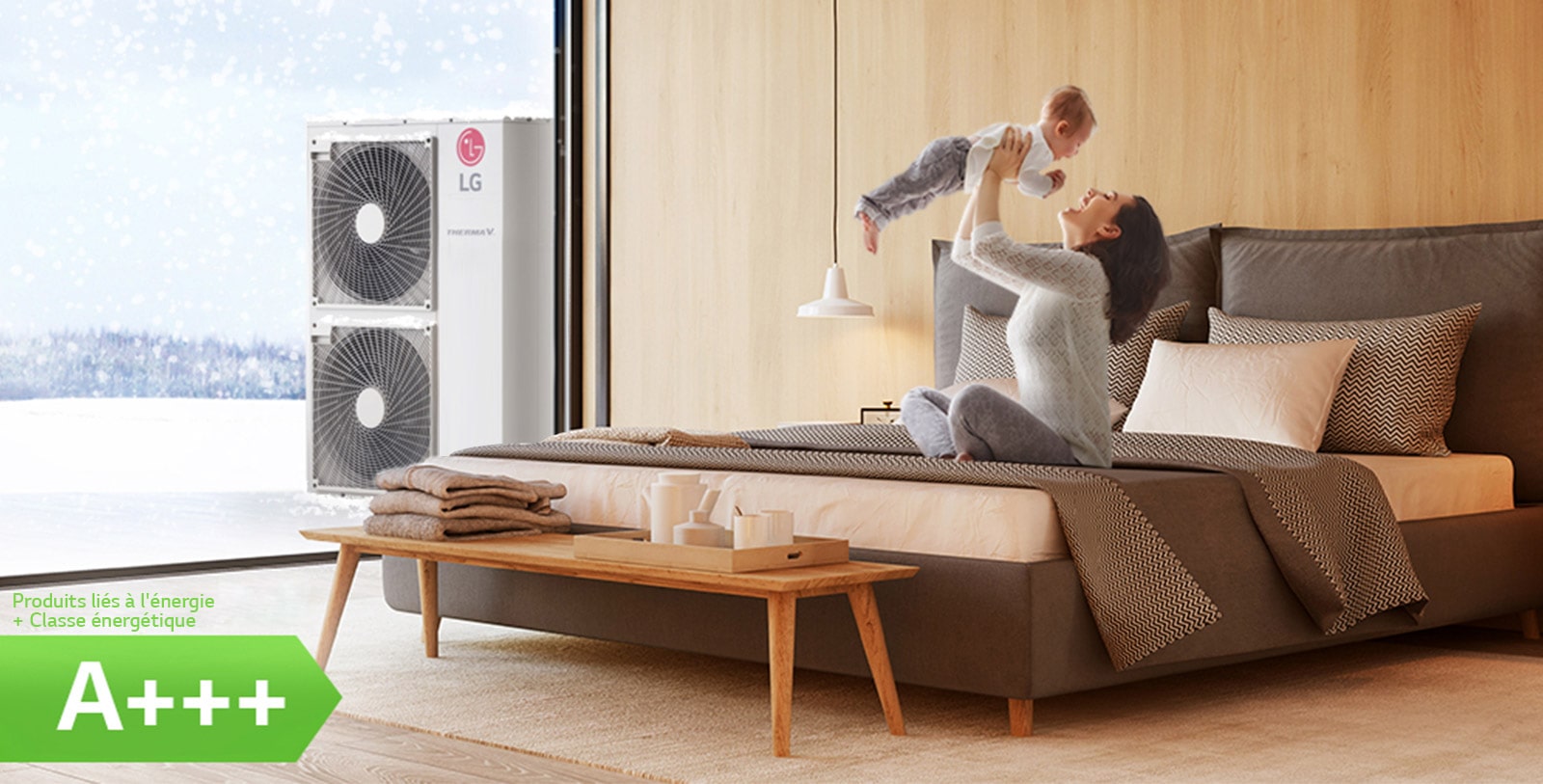 Une mère assise sur un lit dans une pièce tient son enfant en l’air