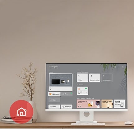 Sur la table, le moniteur affiche l’écran Accueil et l’icône de l’appli LG ThinQ est visible dans le coin inférieur gauche.