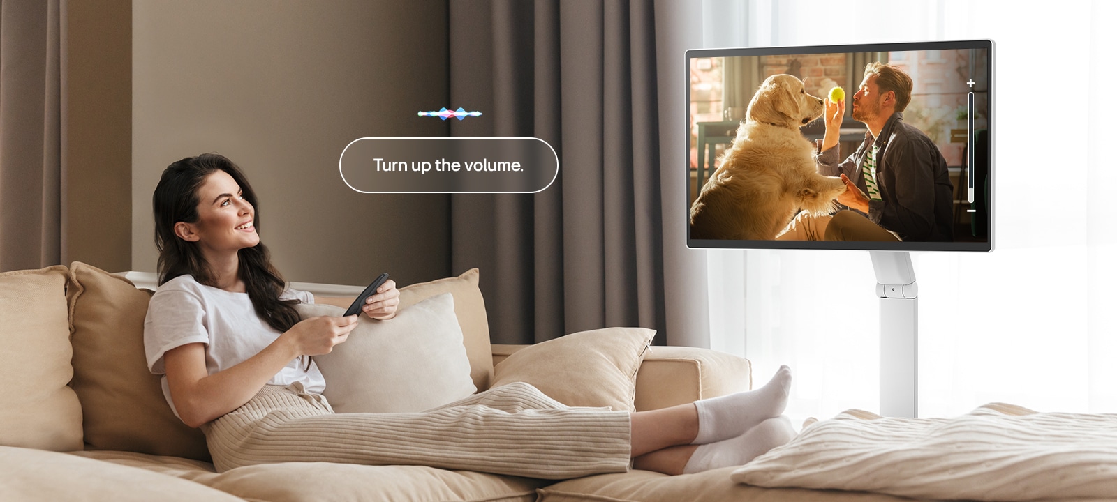 Une femme augmente le volume du LG Smart Monitor Swing avec une télécommande Magic Remote.