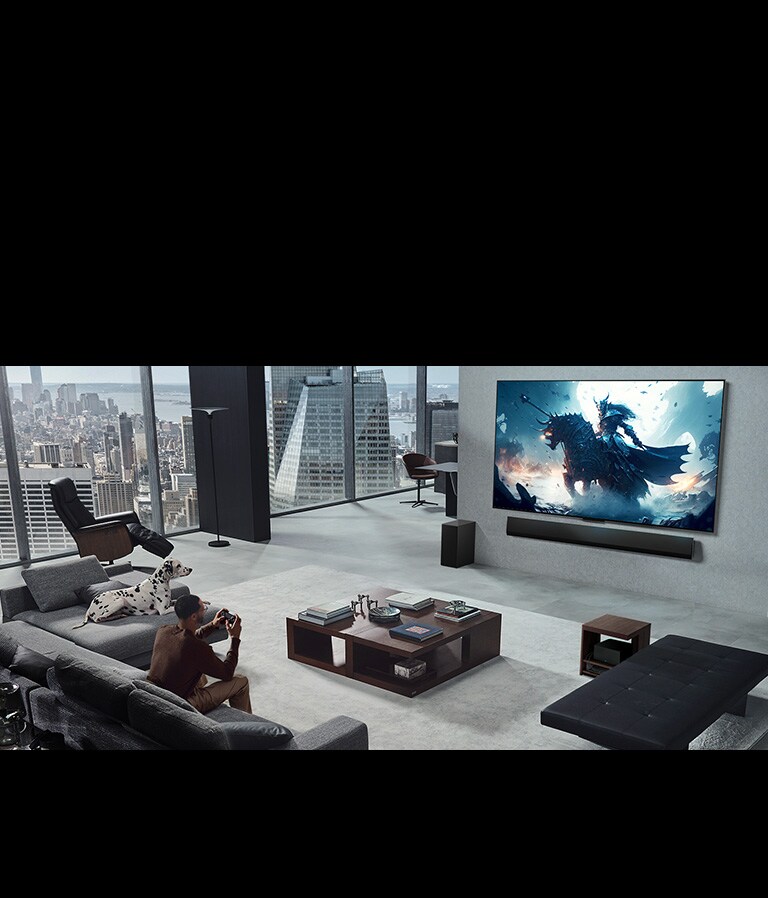 Salon avec une personne jouant à un jeu vidéo sur sa TV LG True Wireless et sa LG Soundbar fixées au mur. Il tient une manette dans sa main, mais la console de jeu n’est pas immédiatement visible. Il n’y a pas non plus de câbles visibles. Le boîtier Zero Connect est rangé, à peine visible sous une table d’appoint.