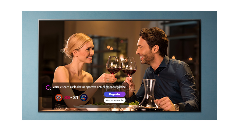 Un homme et une femme en train de trinquer sur un écran de téléviseur alors qu’une alerte sport s’affiche